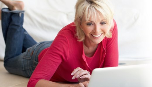 Vrouw liggend achter laptop