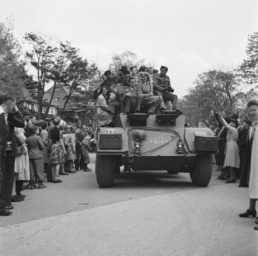 Nederlanders op en langs een tank tijdens de bevrijding